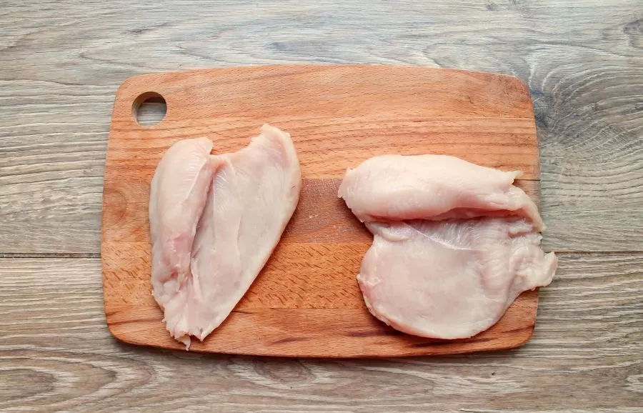 Wash the chicken breast fillet and dry it. With a sharp knife, cut the fillet in half without cutting all the way through and spread it out.