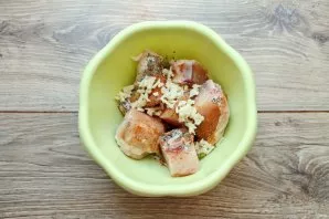 Chicken, cut into portions and put in a bowl. Salt the chicken, pepper it, add adjika, finely chopped garlic and dry basil.