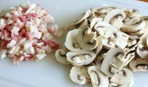 Wash the mushrooms and cut into slices, cut the bacon into cubes.