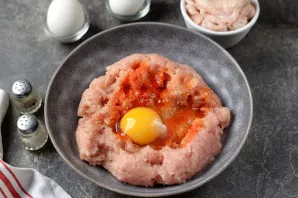 Put the mince in a deep bowl, add salt, pepper to taste, add spices, beat the remaining fresh egg.