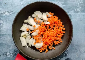 Peel the onion and cut into half rings. Wash the carrots well and cut into small cubes. Put the vegetables in a well-heated pan with vege...