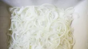 Cut the onion into half rings, then put in a baking dish and sprinkle with a spoonful of olive oil.