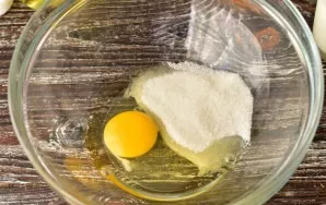 Break an egg into a bowl, add salt and sugar.