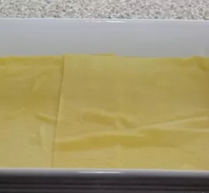 Place a layer of lasagna sheets in a lightly oiled baking dish (if the shape and size of the sheets do not match, the sheets can be cut).