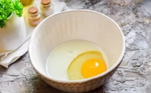 Break an egg into a bowl, add milk.