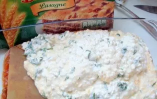 In the first layer, add tomato sauce with minced meat to the mold, lay lasagna sheets on top. We put ricotta.