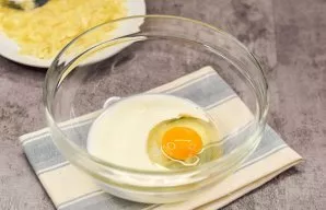 Break a chicken egg into a separate bowl, pour in milk, sugar and a pinch of salt.
