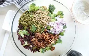 Meanwhile, separate the broccoli with small inflorescences. Cut the bacon and onion into small pieces. Mix everything. Add seeds.