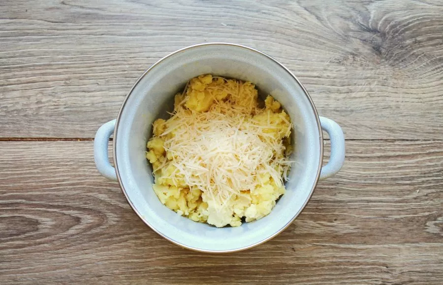 Grate the cheese and put it in a pot with mashed potatoes.