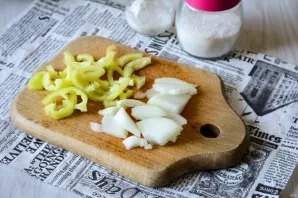 Wash the onion and sweet pepper, peel the onion. Cut the vegetables into strips.