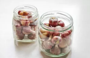Thoroughly wash and dry the jars, put the prepared garlic in them.