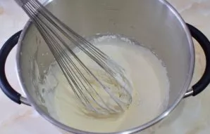 Gradually add the sifted flour and soda to the eggs. Stir with your hands with a whisk so that the mixture remains fluffy.