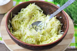 Grate the zucchini, add salt and black pepper to taste. Stir.