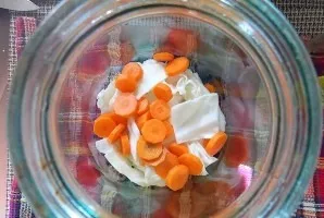 Peel the carrots and cut into slices. Put in a jar with cabbage.