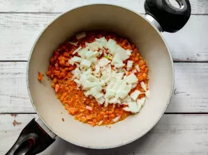 Peel the onion, chop finely and add to the carrots. Bake for 3-4 minutes.
