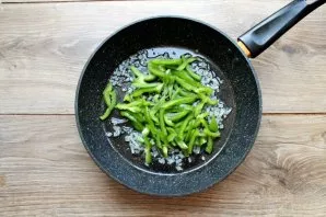 Remove the stalk and seeds of pepper, cut into strips and put in a pan with onion. For another 4-5 minutes, fry the vegetables, stirring.