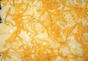 Grease the baking tray with a thin layer of oil and add the potatoes. Then a layer of onions and cheese.