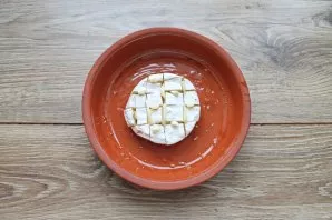 Cut the camembert into squares, without reaching the bottom with a knife. In the cloves put the remaining chopped garlic. Grease the baki...