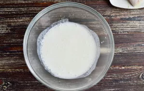 Heat the kefir and pour it into a bowl. Mix it up. At this stage, you will see how the soda will react with the milk product.