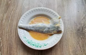 Dip the fish fillet in the egg. Dip it in egg on all sides.