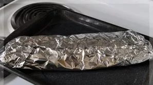 After half an hour, put the ribs on the foil, pack them and put them on a baking sheet.