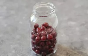 Fill the jar halfway with cherries. First you need to sterilize the jar.