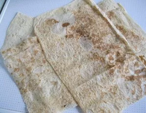 Spread the lavash on a dry surface and cut it in half.