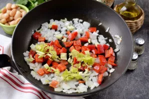 Add chopped celery and bell pepper to the pan, fry for another minute.