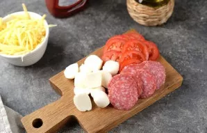 Cut the salami and tomatoes into thin slices.
