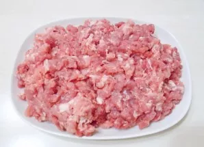 Coarsely grind the pork.