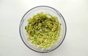 Add chopped horseradish root, bell pepper, peeled garlic and hot pepper to the mixing bowl. Grind everything.