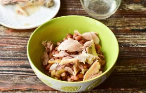 Tear the cooked chicken drumstick into pieces.