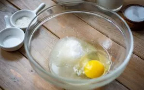 Pour vegetable oil into a spacious bowl, beat an egg, add sugar. Shake these ingredients together.