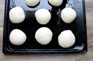Divide the dough into equal pieces. Grease the baking sheet with vegetable oil, roll out the balls from the dough and lay out at a distan...