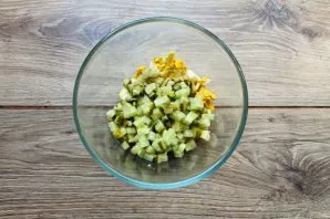 Cut the pickled cucumber into cubes, and also put it in a salad bowl.