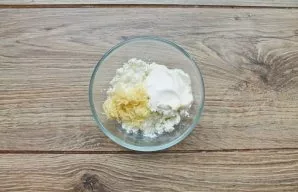 Put cottage cheese, chopped garlic and sour cream in a bowl. Blend everything with a blender until smooth.