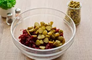 Cut the pickled cucumbers into small slices. Transfer the cucumbers to a bowl with beets.