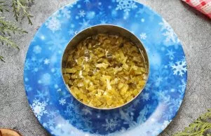 Cut pickled cucumbers into small cubes and put on top of the potatoes and press down.