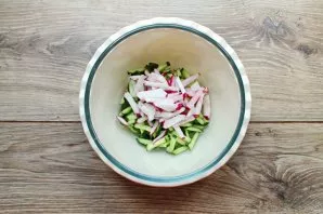 For radishes, cut off the tails, cut into strips and shake into a bowl with cucumbers.