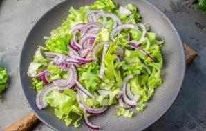 Cut the lettuce leaves into small pieces. Add the onion chopped into thin slices. Gently mix them together.