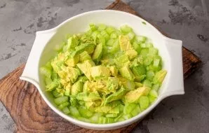 Cut the ripe avocado in half, remove the dice and avocado pulp. Cut the pulp into medium cubes, put in a bowl with celery.