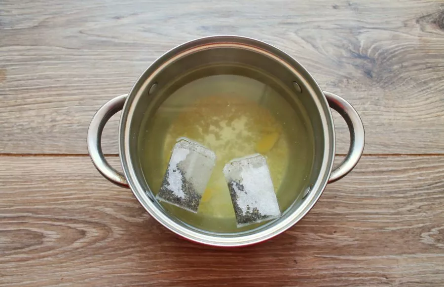 Remove the ginger slices from the pot and add the green tea.