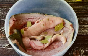 Put the fish in a container that you can cover later, add whole pepper and bay leaves, the bay leaves are divided into several parts.