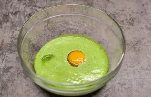 Using a blender, crush the spinach and milk until smooth. Break an egg into a bowl, add salt and sugar.