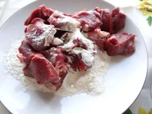 Cut the beef into pieces and roll it in flour.
