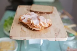 We lay several folded slices of sausage on the bread.