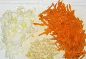 Grate the carrots on a coarse grater, cut the onion into cubes, and chop the garlic or throw it through a garlic press.