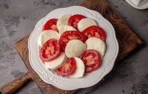 Alternately lay out the tomatoes and cheese on a flat plate.