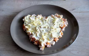 Coat the chicken layer with mayonnaise, sprinkle finely chopped garlic on top.