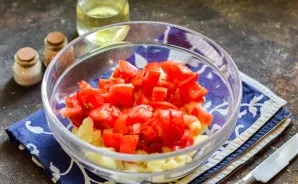 Then wash and dry the tomatoes, remove the place of growth of the stem. Cut the tomatoes into small cubes and add to the potatoes.